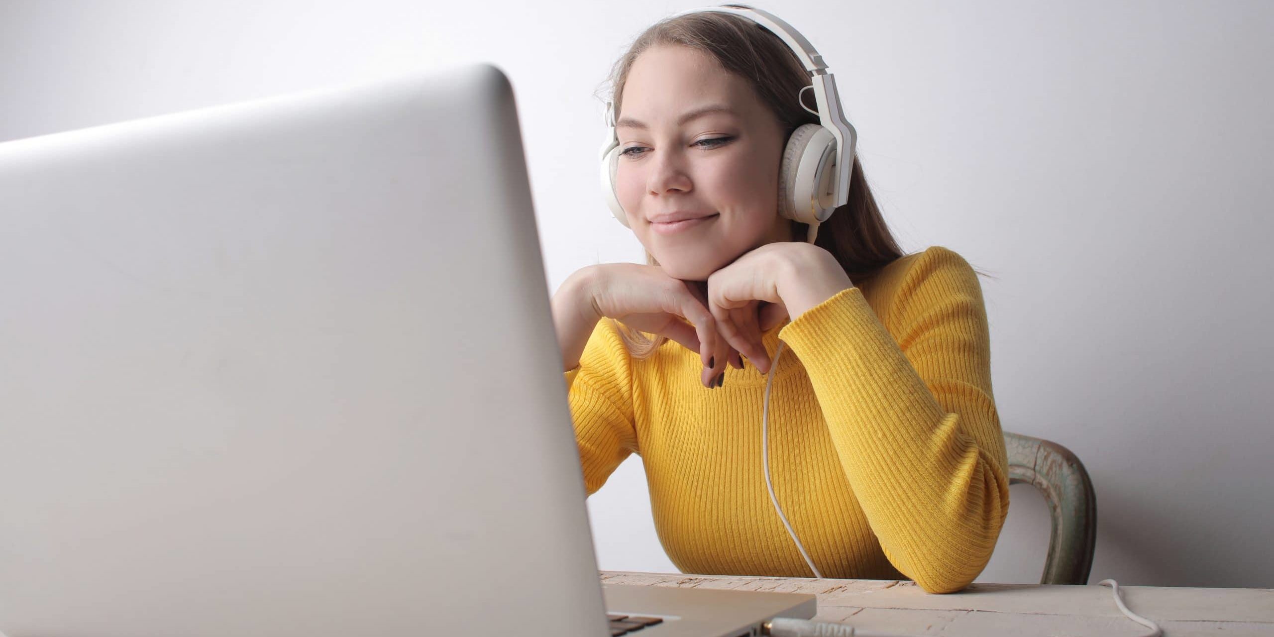woman-in-yellow-sweater-wearing-headphones-using-laptop-3885744